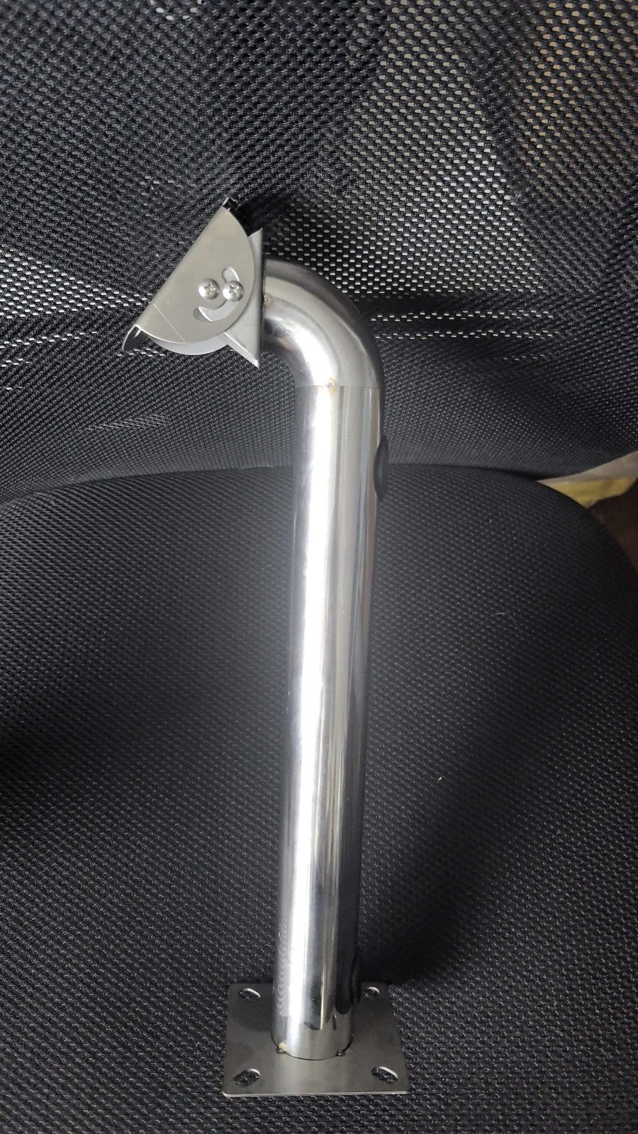 Elbow stainless bracket fixed to a textured panel