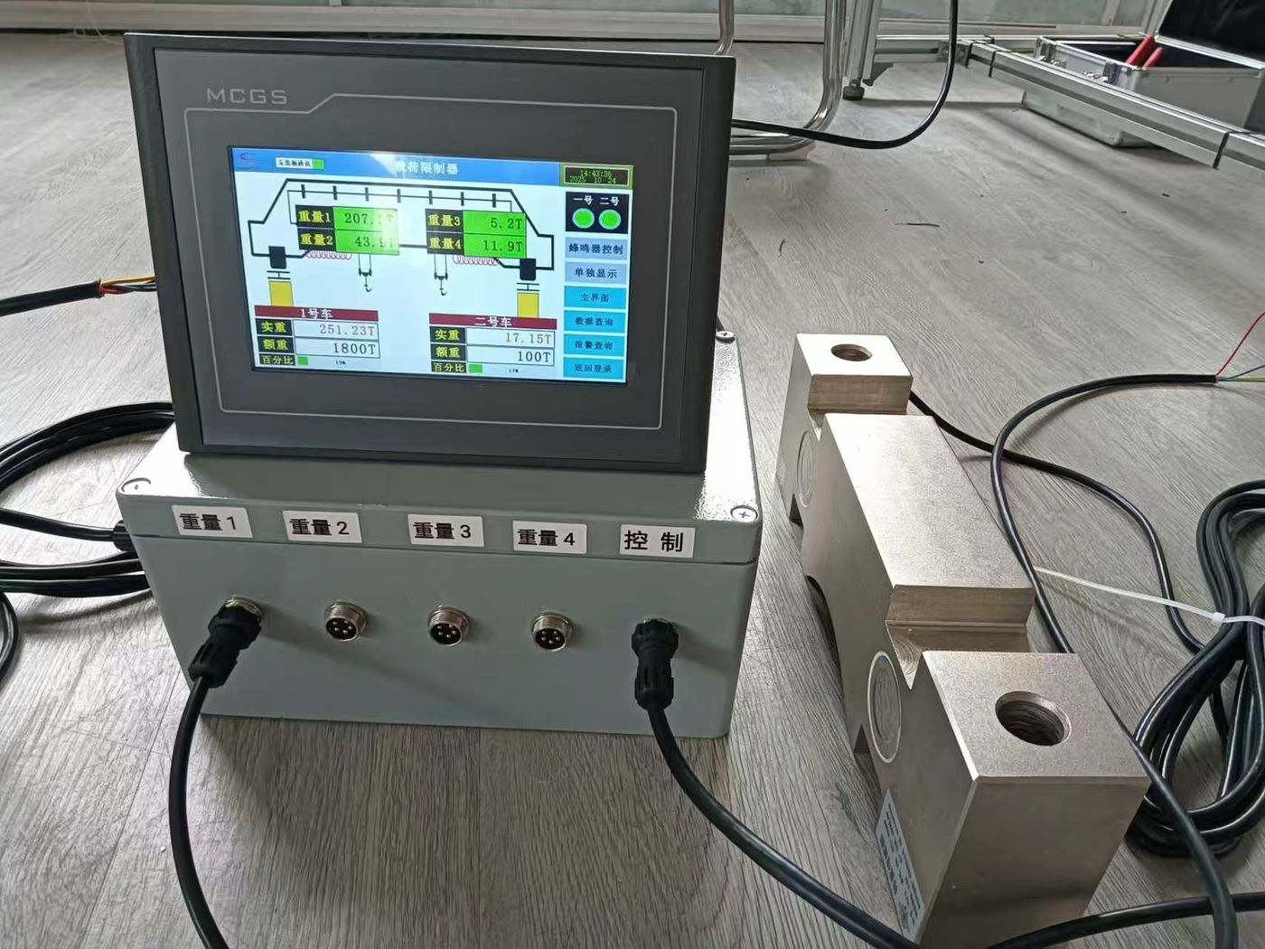 Screen showing a multi-channel load page on a desk, a grey junction box with a row of ports in front and two block cells at right