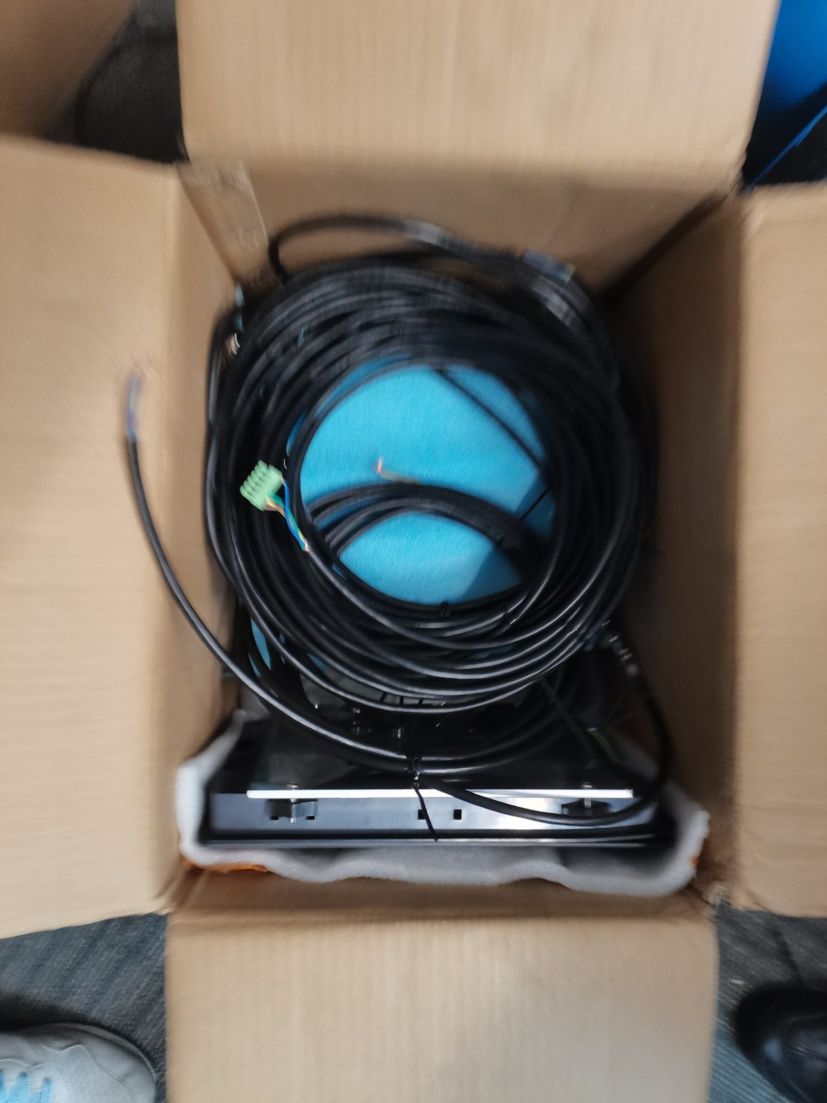 Carton holding a coiled cable reel and a boxed terminal