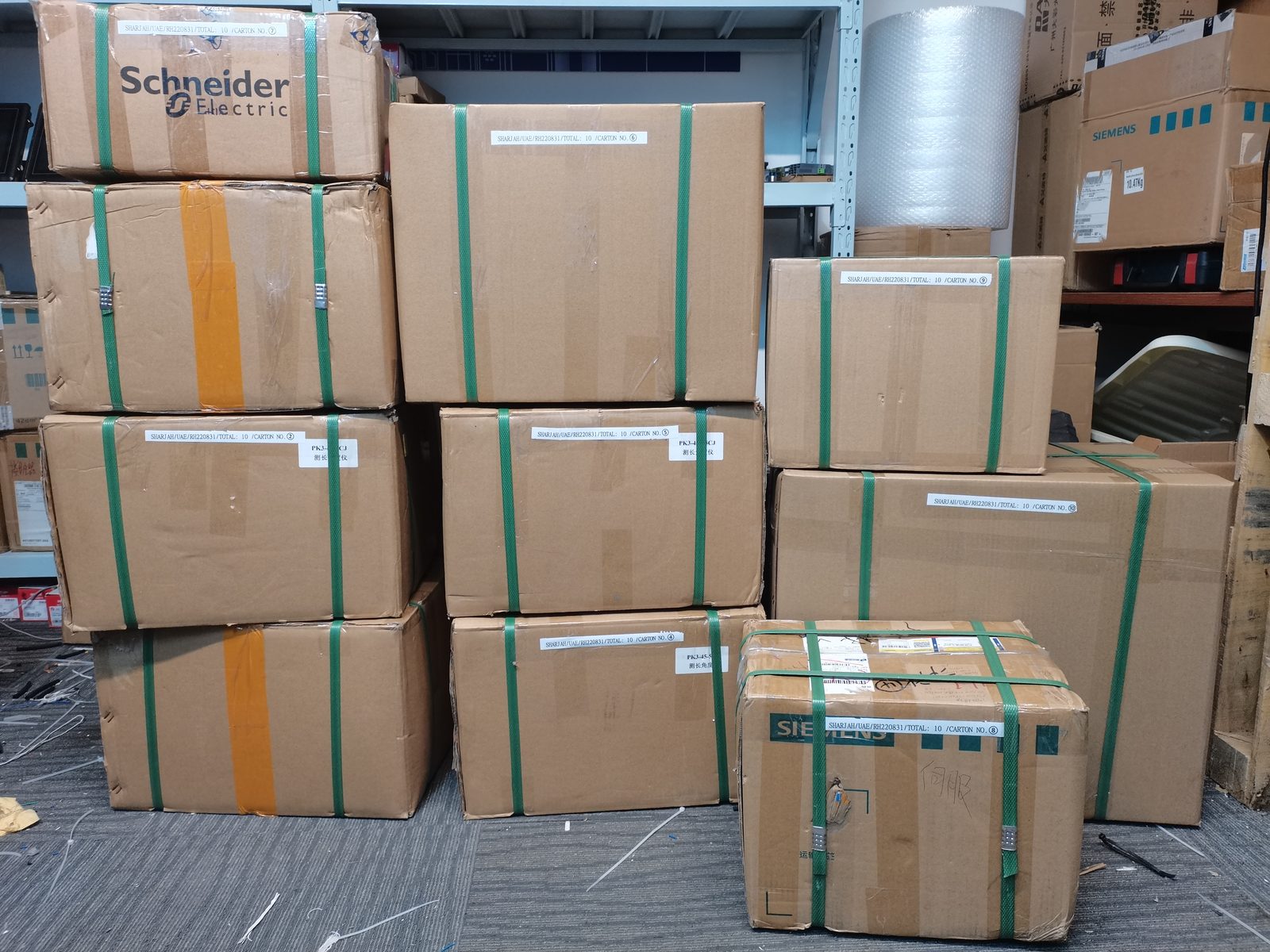 Stacked export cartons held with green strapping in the warehouse