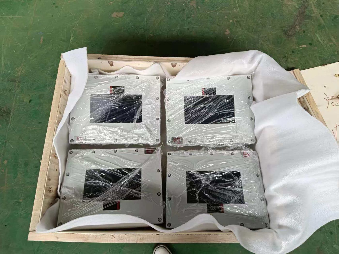 Four terminals wrapped in foam and stretch film, two by two, inside a wooden crate