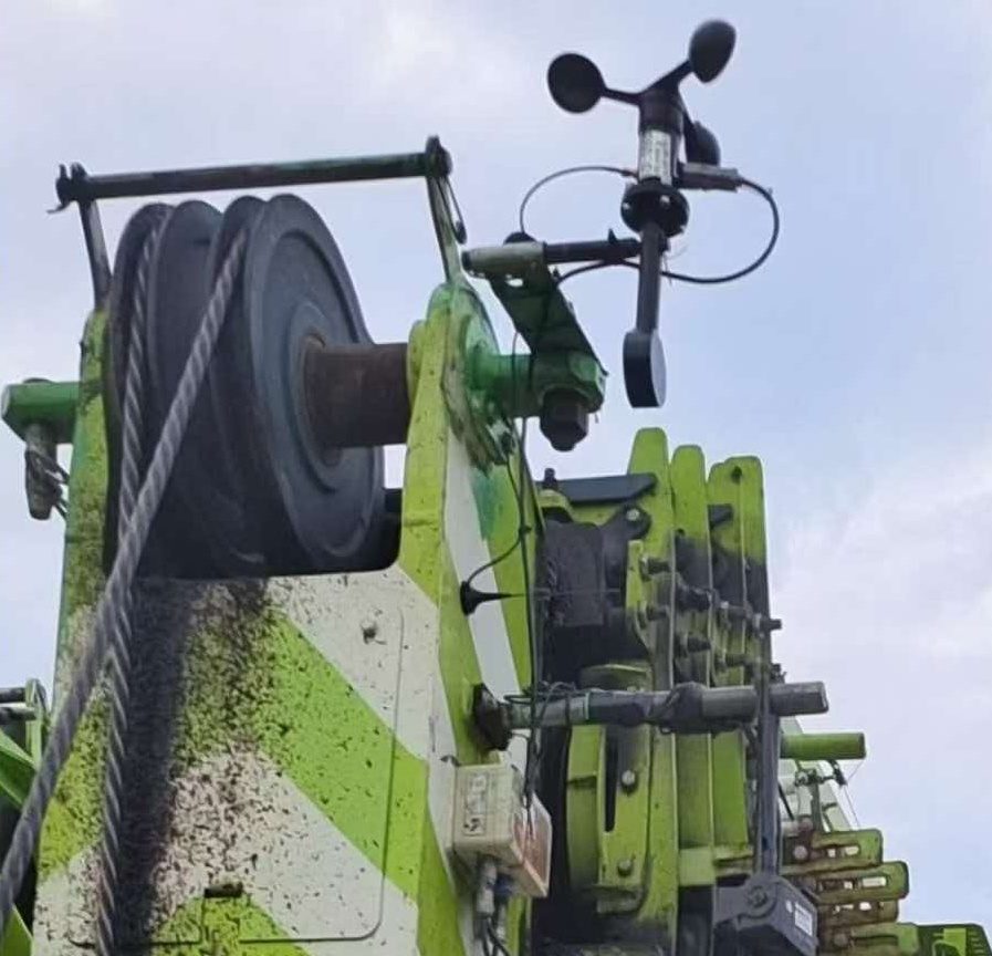 Anemometer mounted above the head of a green lattice boom