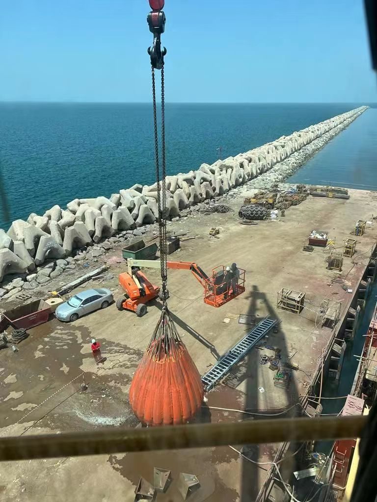Crane lifting elements along an offshore breakwater