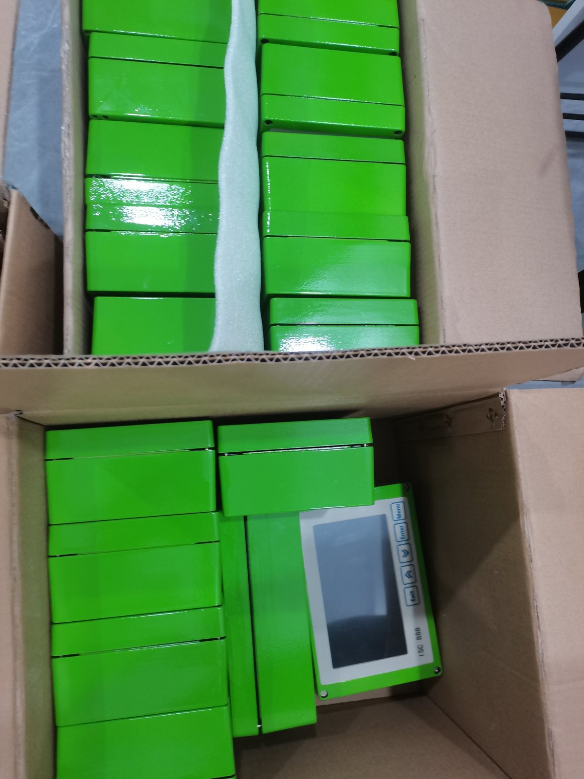 Carton dividers holding green boxed units and a terminal